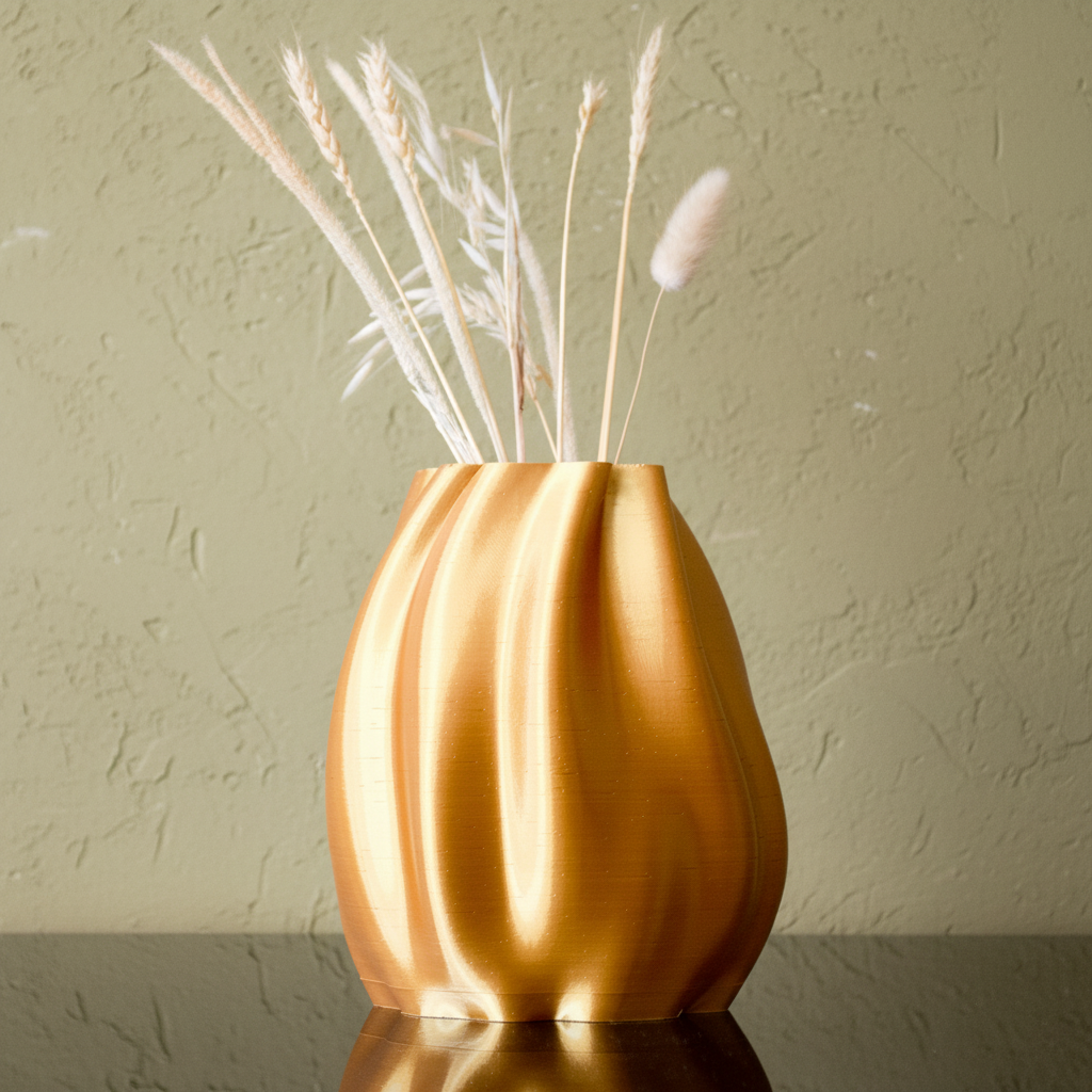 Gold vase with dried plants on a light blue background