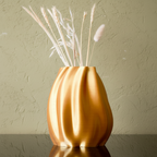 Gold vase with dried plants on a light blue background