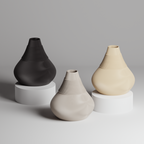 Three ceramic vases in black, gray, and beige on a neutral background