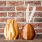 Two vases on a wooden surface with a light gray background