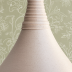 Close-up of a textured vase against a light blue background