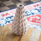 Geometric vase on a wooden surface with a patterned rug in the background