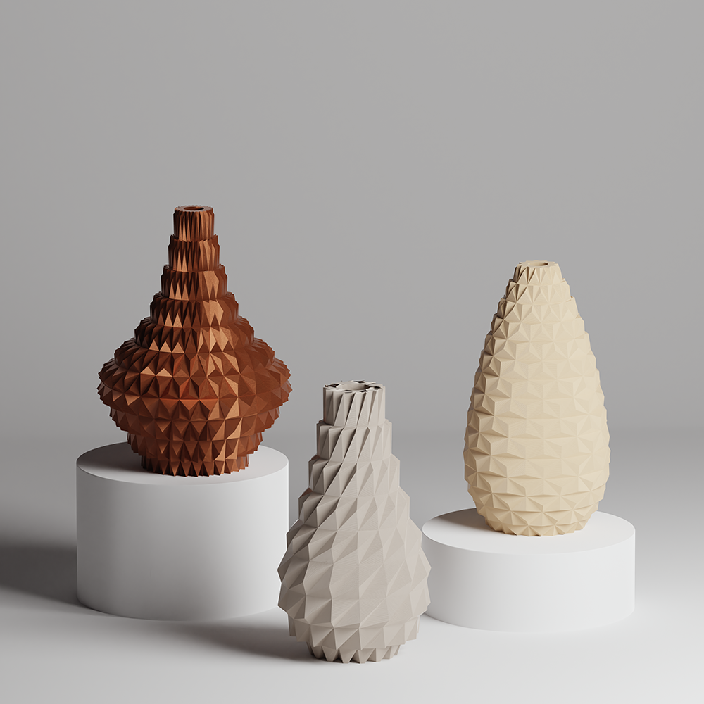 Three geometrically designed vases on white stands against a gray background