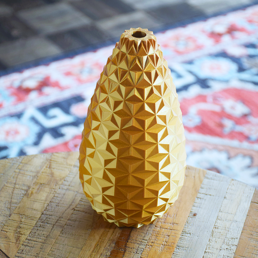 Yellow geometric-patterned vase on a textured surface with a colorful rug in the background
