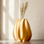 Gold vase with dried plants on a light background